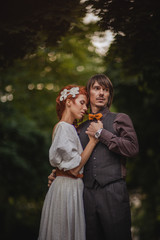 Obraz premium romantic couple hugging on blurred green forest background