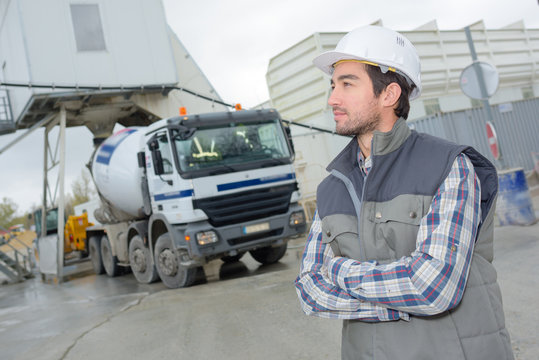 male engineer standing in front of truck on building site