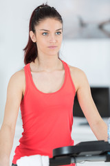 Fototapeta na wymiar teenager girl exercising on stepper trainer