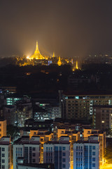 Yangon and lit Shwedagon Pagoda in Myanmar viewed from above in the evening.