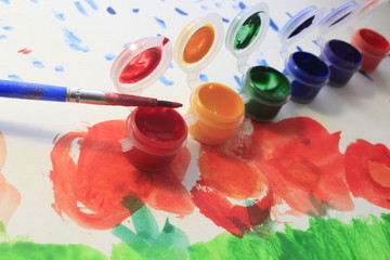 This is a set of paints, a brush and children's drawings