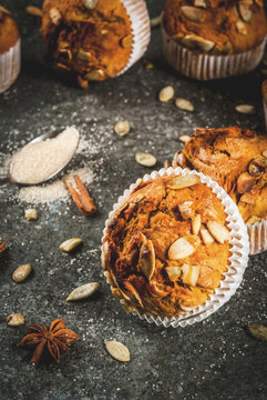 Autumn and winter baked pastries. Healthy pumpkin muffins with traditional fall spices, pumpkin seeds. Black stone table, copy space