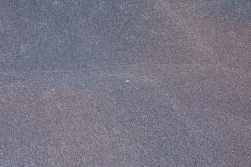 Gray black fine sea beach sand grains closeup as background