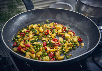Frying colourful fresh vegetables in a frying pan