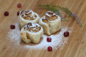 Strudel with apples and cranberries on wood background