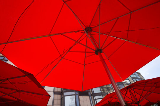 Three red patio umbrellas as seen from bottom. Cafe umbrellas filling frame close up