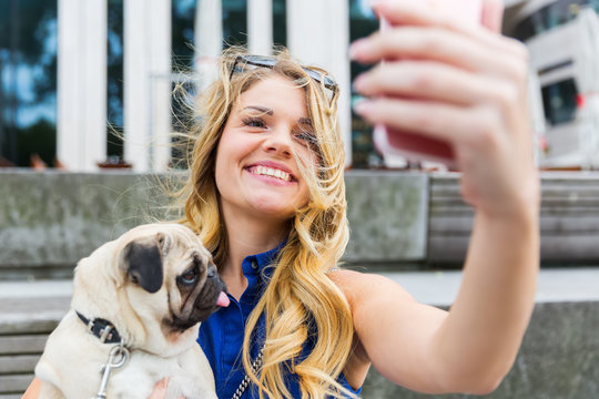 young woman with pug makes a selfie