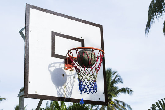 Basketball game outdoor equipment contrast photo. Accurate ball throw in basket.