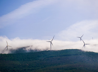 some wind turbines on a mountain in the north of Morocco surrounded with clouds