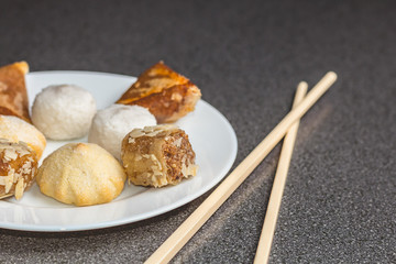 Delicious assortment of homemade Asian pastries. Samosas with a rose flower and banana balls