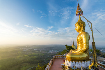 Big gold Buddha statue at the sunrise in Tiger Cave Temple in Krabi province, Thailand 