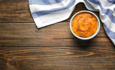 Ramekin with tasty carrot souffle on wooden table