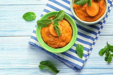 Ramekins with tasty carrot souffle on wooden table