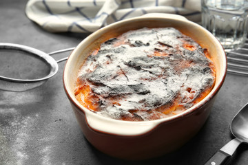 Baking dish with tasty carrot souffle on table