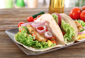 Plate with delicious fish tacos on kitchen table
