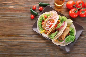 Plate with delicious fish tacos on kitchen table