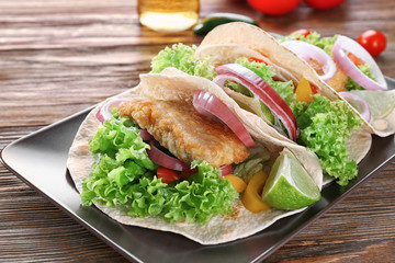 Plate with delicious fish tacos on kitchen table