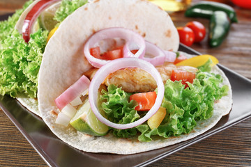 Plate with delicious fish taco on kitchen table