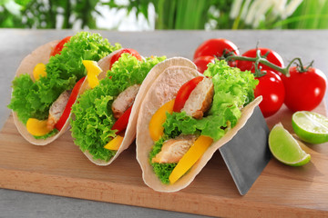 Holder with delicious fish tacos on wooden board