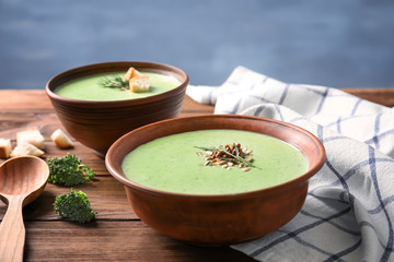 Bowl with delicious broccoli soup on table