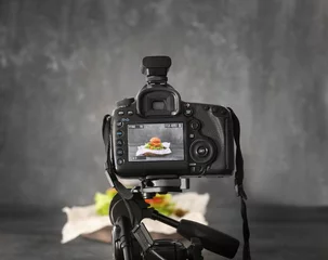 Fototapeten Professional camera on tripod while shooting food © Africa Studio