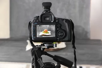 Poster Professional camera on tripod while shooting food © Africa Studio