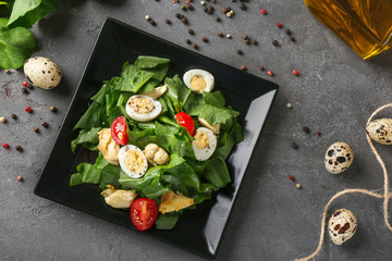 Plate of salad with quail eggs and spinach on table