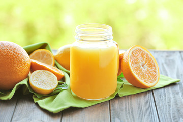 Fototapeta na wymiar Mason jar with delicious orange juice on table
