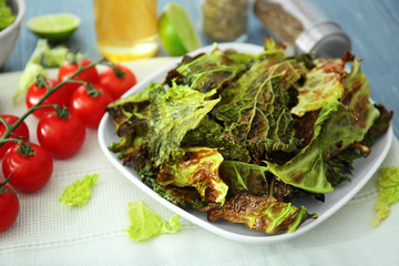 Plate with lettuce chips on table