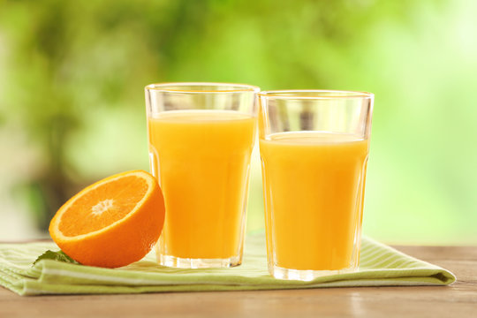 Glasses with delicious orange juice on table