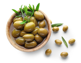Wooden bowl with green olives on white background