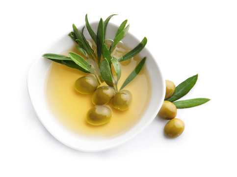 Bowl with olives and oil on white background
