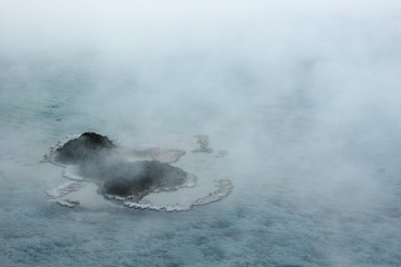 Excelsior Geyser's vast pool covered in steam, looks like fairyland islands