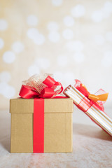 Christmas design with present in gold wrapping and red ribbon with space for text