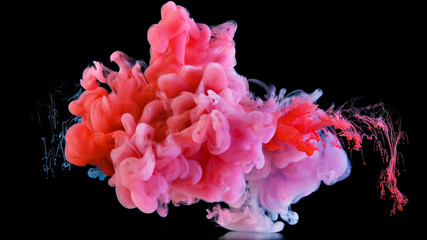 Obraz premium Real shot color paint drops in water. Ink swirling underwater. Cloud of ink collision isolated on black background. Colorful abstract smoke explosion. Close up view