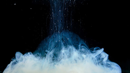 White paint drop mixing in water towards to camera. Ink swirling underwater. Cloud of ink isolated...
