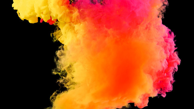 Colorful rainbow paint drops from above mixing in water. Ink swirling underwater. Cloud of ink isolated on black background. Colored abstract smoke explosion effect. Close up view