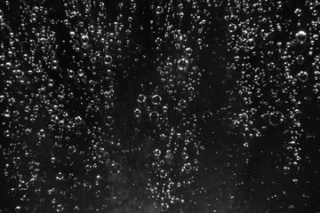 Rain drops on the glass on a black background