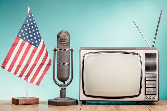 USA flag, retro old microphone and TV set front gradient mint green wall background. Vintage instagram style filtered photo