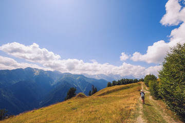 Woman hiking in mountains and meadows of Svaneti national park, Georgia