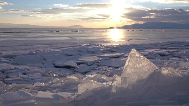 Dolly shot of gorgeous sunset over small icebergs and icicles