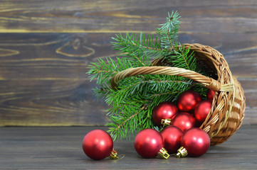 Christmas ball decoration and tree branches in the basket on wooden background with copy space.  Holiday concept.  