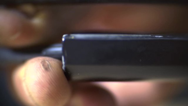 Men's hands shoved the guide rod into the disassembled gun, macro shooting