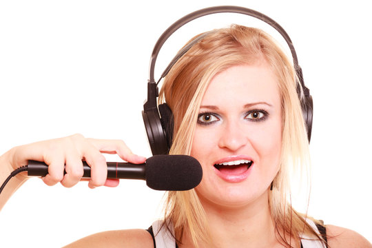 Woman singing to microphone wearing headphones