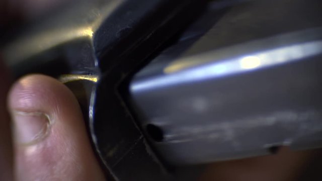 The cartridge clip with a idle patron is inserted into the pistol, macro shooting