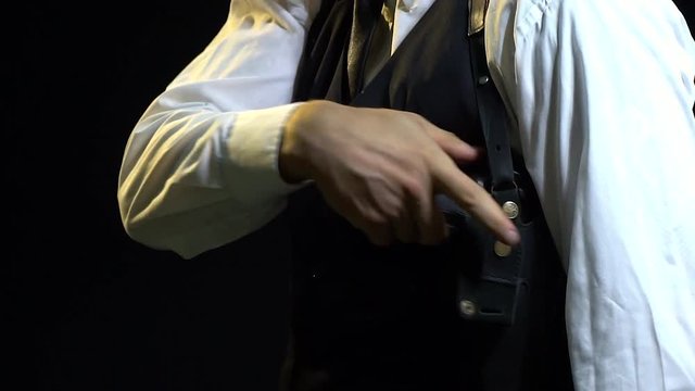 The man in the suit turns the gun in his hand and puts it in the kobok and gets it again