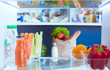 Open refrigerator with fresh fruits and vegetable