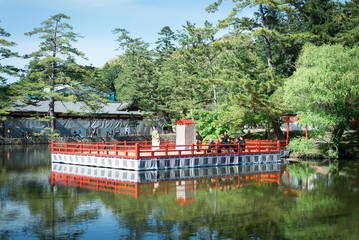 Stella at the entrance to the town, against green forest background.