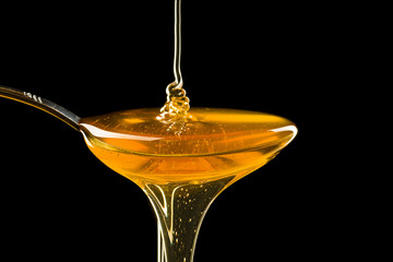 Spoonful of honey on the black background