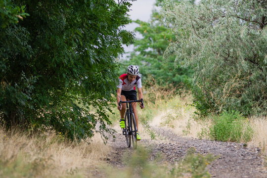 Biycle rider on cyclocross bike training outdoor on gravel  country road 